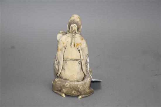 A Chinese carved ivory group of a sage holding a peach, seated beside a crane and a deer, 17cm